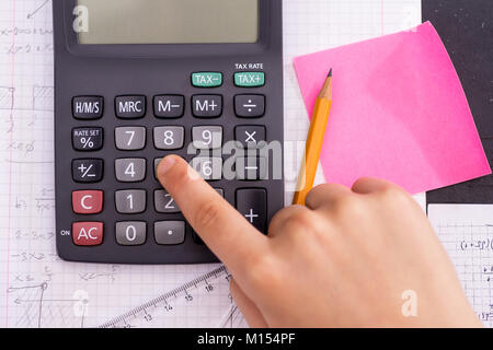 Mit dem Finger auf dem Rechner Taste Während der Mathematischen Lektion. Schule Konzept. Stockfoto