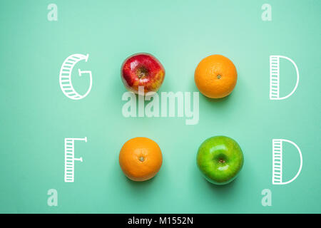 Hand Schrift Essen auf Türkisfarbenem Hintergrund mit Obst Orangen Grün rote Äpfel. Gesunde, saubere Essen vegane Vitamine Energiekonzept. Kreative Mi Stockfoto