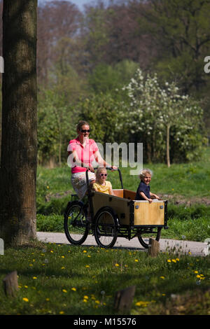 Die Niederlande, 's-graveland. Mutter und 2 Kinder auf angepasste Fahrrad. Stockfoto