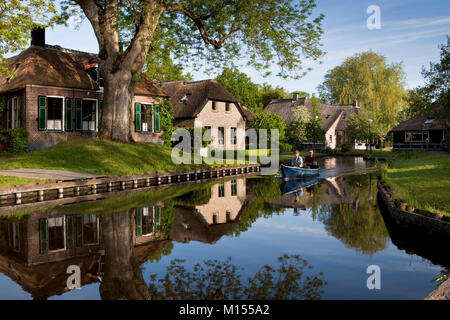 Die Niederlande, Dwarsgracht, in der Nähe von Giethoorn, Dorf mit fast nur Wasserstraßen. Touristische Paar beim Boot fahren. Stockfoto