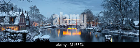 Die Niederlande, Vreeland, Weihnachtsbaum und beleuchtete Zugbrücke über den Fluss genannt: Vechte. Dämmerung. Winter, Schnee. Panoramablick. Stockfoto