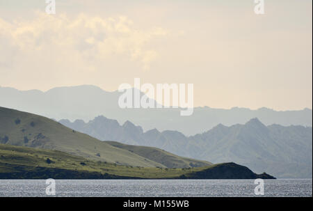 Dämmerung vor Sonnenaufgang auf dem Ozean Küste. Meer und Berge Landschaft am nebligen Morgen. Insel Komodo. Molukken, indonesischen Molukken, Spice Isla Stockfoto