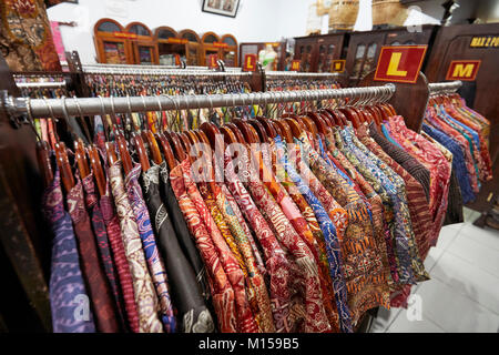 Bunte Seide batik Hemden auf einem Regal in Hamzah Batik Shop. Yogyakarta, Java, Indonesien. Stockfoto