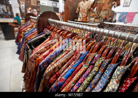 Bunte Seide batik Hemden auf einem Regal in Hamzah Batik Shop. Yogyakarta, Java, Indonesien. Stockfoto