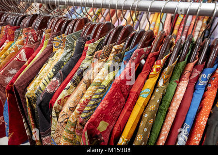 Bunte Seide batik Hemden auf einem Regal in Hamzah Batik Shop. Yogyakarta, Java, Indonesien. Stockfoto