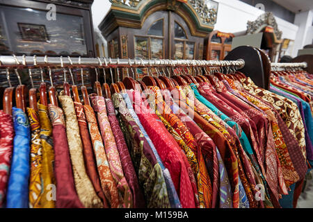 Bunte Seide batik Hemden auf einem Regal in Hamzah Batik Shop. Yogyakarta, Java, Indonesien. Stockfoto