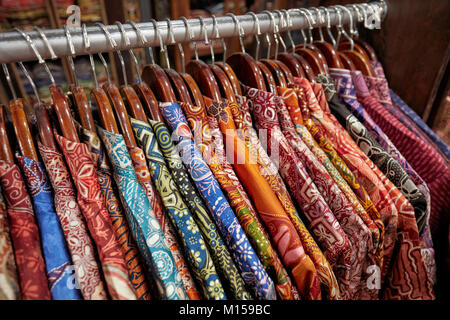 Bunte Seide batik Hemden auf einem Regal in Hamzah Batik Shop. Yogyakarta, Java, Indonesien. Stockfoto