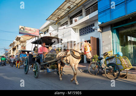 Pferdewagen als Verkehrsmittel entlang der Jalan Pajeksan Pajeksan (Straße). Yogyakarta, Java, Indonesien. Stockfoto