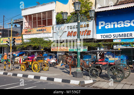 Pferdekutschen warten auf Kunden auf Malioboro Street entfernt. Yogyakarta, Java, Indonesien. Stockfoto