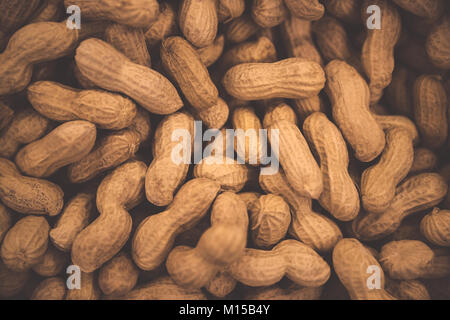 Erdnüsse Hintergrund, lecker hochkalorische Nüsse, monkey Muttern in der Nussschale, abstrakte Erdnüsse Hintergrundbild Stockfoto