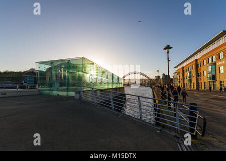 Newcastle, England - 31. Dezember 2017: die Menschen gehen mit Newcastle Quayside nahe dem Eingang der Gateshead Millennium Bridge am Nachmittag Stockfoto