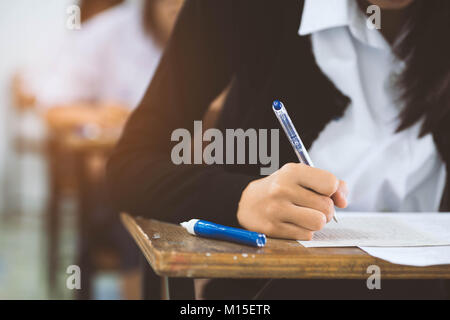 Nahaufnahme der Hand des Schüler Lesen und Schreiben Prüfung mit Stress im Klassenzimmer. Stockfoto