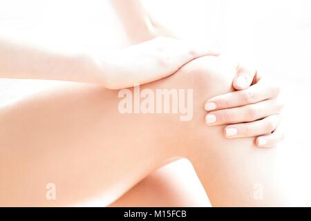 MODEL RELEASED. Junge Frau in Schmerzen ihrer wunden Knie rieb. Stockfoto