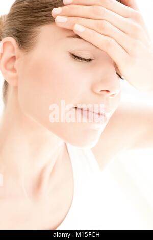 MODEL RELEASED. Junge Frau in Schmerzen mit Kopfschmerzen, aus der Nähe. Stockfoto