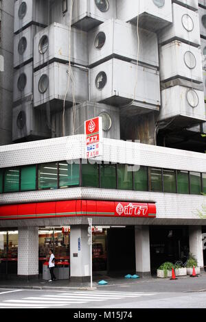 Blick auf den Convenience Store an der Basis der ikonischen Kisho Kurokawa entworfene Nakagin Capsule Tower. (April 2017) Stockfoto