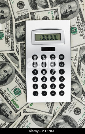 Geschäft Hintergrund. Taschenrechner mit Millionen auf dem Display liegen auf dem Hintergrund des Geldes. Close-up Stockfoto