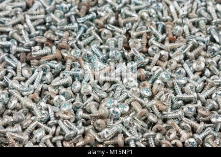 Hintergrund Textur von einem Stapel von Schrauben. Schwarze Schrauben abstrakt Hintergrund. Blick von oben. Stockfoto