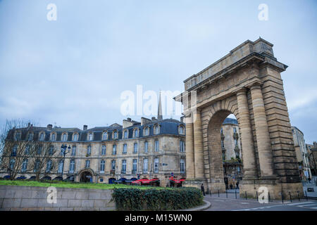 BORDEAUX, Frankreich - 24. Dezember 2017: Burgundische Pforte (Porte de Bourgogne) in der Dämmerung mit traditionellen Bordeaux Gebäude hinter. Dieser Bogen ist eine der r Stockfoto