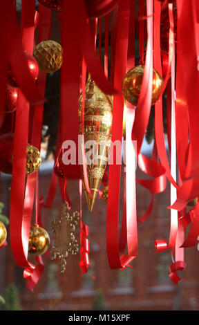 Schönes Foto von Weihnachtsschmuck unter den roten Bändern Stockfoto