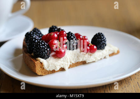 Käsekuchen mit Brombeeren und roten Johannisbeeren Stockfoto