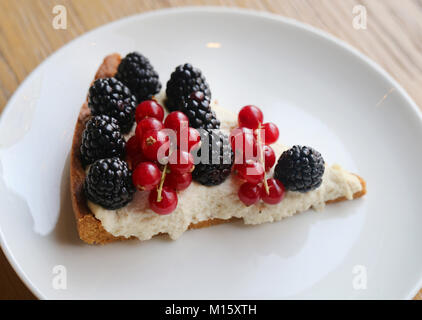 Käsekuchen mit Brombeeren und roten Johannisbeeren Stockfoto