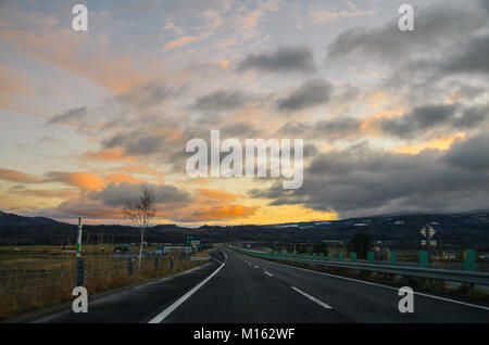 Schöne Aussicht auf den Sonnenuntergang entlang der Straße von Asahikawa Hokkaido in Sapporo, der größten Stadt. Fahren in Hokkaido ist erstaunlich。 Stockfoto