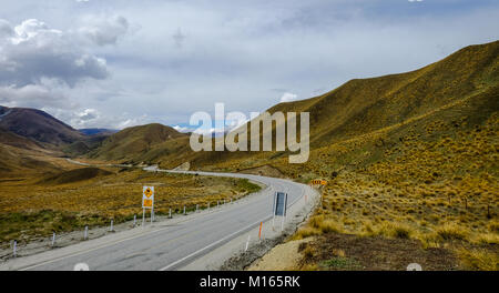 Mountain Road mit getrocknetem Gras über den Lindis Pass in die Südinsel von Neuseeland. Stockfoto