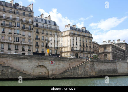 Wohnblocks entlang der Seine mit Treppe auf der Bank führt zum Fluss, Paris, Frankreich. Stockfoto