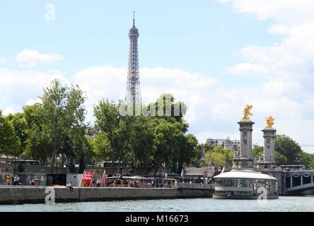 Blick auf den Eiffelturm, Stationär schwimmendes Restaurant Taverne namens Rosa Bonheur sur Seine und vergoldeten Fames Skulpturen auf dem Sockel Gegengewichte auf t Stockfoto