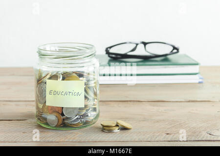 Münzen in Glas Glas mit Bildung label. Kosteneinsparungen, Bildung oder College Fund, planen und träumen Konzept, kopieren. Stockfoto