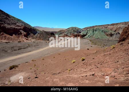 Wüstenlandschaft mit Schmutz der Straße im Rainbow Valley, Valle Arcoiris, in der Nähe von San Pedro de Atacama, Región de Antofagasta, Chile Stockfoto