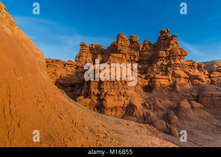 Goblins oder Hoodoos von Entrada Sandstein erodiert, durch Sonnenuntergang Licht beleuchtet, im Goblin Valley State Park, Utah, USA Stockfoto