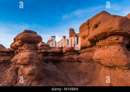 Goblins oder Hoodoos von Entrada Sandstein erodiert, durch Sonnenuntergang Licht beleuchtet, im Goblin Valley State Park, Utah, USA Stockfoto