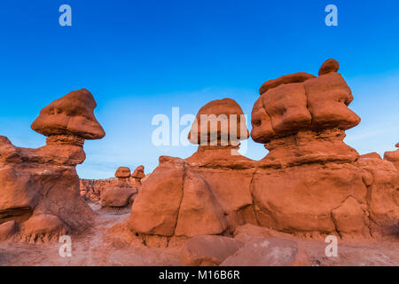 Goblins oder Hoodoos von Entrada Sandstein erodiert, durch Sonnenuntergang Licht beleuchtet, im Goblin Valley State Park, Utah, USA Stockfoto