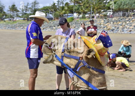 Touristen REITEN KAMELE AM STRAND Stockfoto