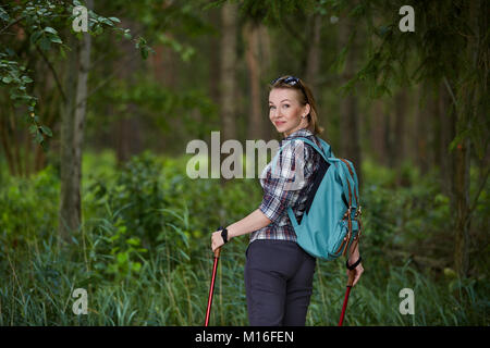 Junge Frau mit Nordic Walk pols Stockfoto