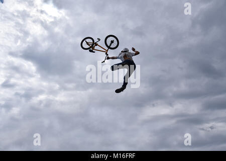 Die Silhouette eines jungen Mannes freestyle stunt Radfahrer in den Himmel darstellenden Stunt springen von einem Skatepark Rampe fliegen Stockfoto