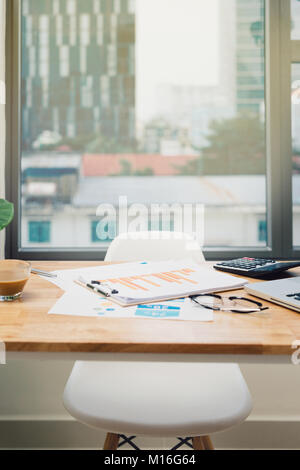 Büro Arbeitsplatz mit Laptop auf Holz Tisch gegen die Fenster. Stockfoto