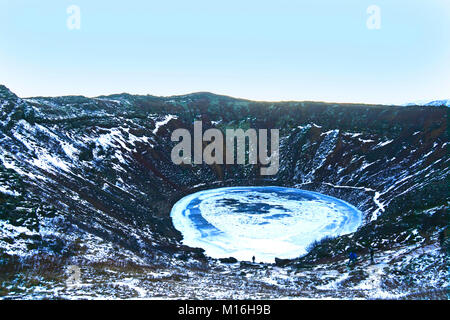 Kerið ist ein Vulkankrater See in Grímsnes im Süden Islands. Es ist ein beliebter Stopp, wenn der Golden Circle reisen. Es wird geglaubt, dass Kerið ursprünglich war ein Kegel Vulkan, die ausbrach und die Magma finden geleert. Sobald die Magma erschöpft war, das Gewicht des Kegels stürzte in ein leeres Magmakammer, später mit Wasser gefüllt werden. Die kerið Caldera besteht aus vulkanischem Gestein und ist rund 55 m Tiefe, 170 m breit und 270 m. Es gibt nur wenig Vegetation in den steilen Wänden des Kraters, Speichern für eine Wand mit einer sanfteren Steigung, die mit tiefen Moos bedeckt ist. Kerio - Island Stockfoto