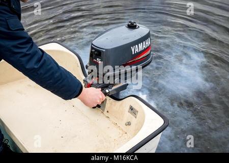 Haugesund, Norwegen - Januar 10, 2018: der Mann, der Sie ein Yamaha Außenbordmotor auf einem Boot, Rauch aus dem Motor. Stockfoto