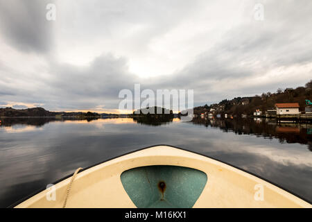 Nedstrand in Norwegen - Januar 10, 2018: Blick von der Vorderseite eines kleinen Motorboot fahren in das Wasser in der Förde Forresfjorden in der norwegischen Westküste. Schönen Himmel und blaues Licht Stockfoto