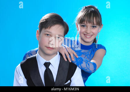 Jungen und Mädchen posiert im Studio auf blauem Hintergrund Stockfoto