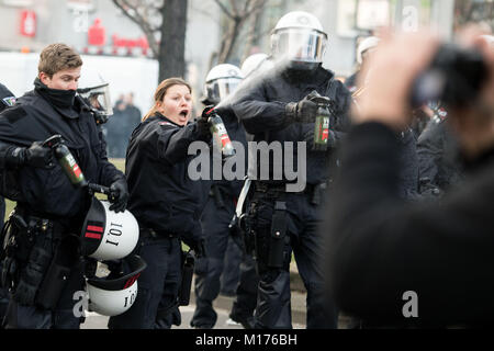 Polizisten mit Pfefferspray gegen Demonstranten an einer kurdischen Demonstration gegen die türkische Militäroffensive im Norden Syriens, in Köln, Deutschland, 27. Januar 2018. Foto: Marius Becker/dpa Stockfoto