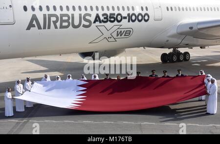 Doha, Katar. 27 Jan, 2018. Qatar Airways Mitarbeiter halten eine nationale Flagge Katar neben einem Airbus A350-1000 Jet am internationalen Flughafen von Doha in Doha, der Hauptstadt von Katar, Jan. 27, 2018. Die Marke neue Flugzeuge, die in Doha im Rahmen der Demonstration Tour 12 Naher Osten und Asien-Pazifik-Destinationen angekommen. Credit: Nikku/Xinhua/Alamy leben Nachrichten Stockfoto