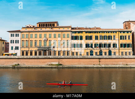 Die ruderer auf dem Fluss Arno in Pisa, Toskana, Italien mit herrlichem Bunte italienische Architektur im Hintergrund Stockfoto