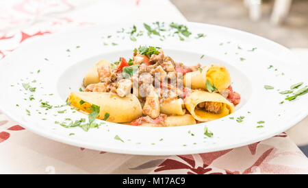 Otranto Stadt, Region Apulien, im Süden von Italien. Traditionelle Paccheri Pasta mit Schwertfisch, serviert mit Tomaten, Petersilie, Olivenöl. Tageslicht, echten Res Stockfoto
