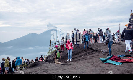 Massen von Menschen versammeln sich auf der Oberseite des Mount Batur - eine beliebte Tradition der täglich den Sonnenuntergang geniessen Sie während der Eruption auf Agung Vulkan Mount Stockfoto