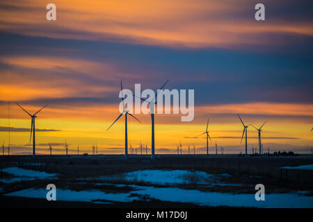 Schönen Sonnenuntergang mit Silhouetten von Windmühlen im Vordergrund; Schnee auf dem Boden; Colorado, USA Stockfoto