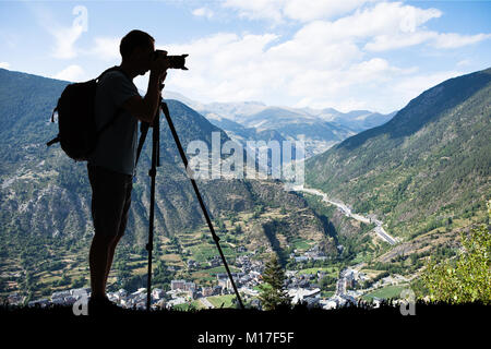 Silhouette eines Mannes mit Rucksack Fotografieren im Winter mit Stativ Stockfoto