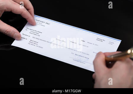 Nahaufnahme einer Businessperson Unterzeichnung Prüfen mit Stift Stockfoto